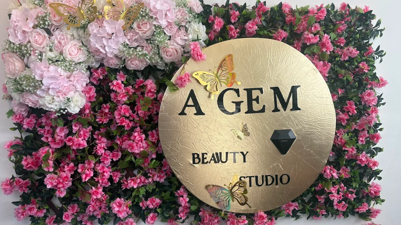 A Gem Beauty Studio gold signage on a floral wall
